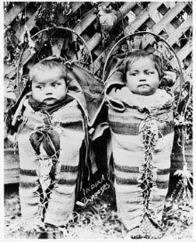 Enfants sanglés dans des planches porte-bébés. (Bibliothèque et Archives Canada).